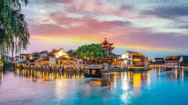 Historic riverside water town illuminated at sunset in Thailand