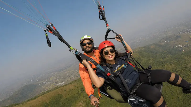 Couple enjoying tandem paragliding over Bir Billing near Dharamshala