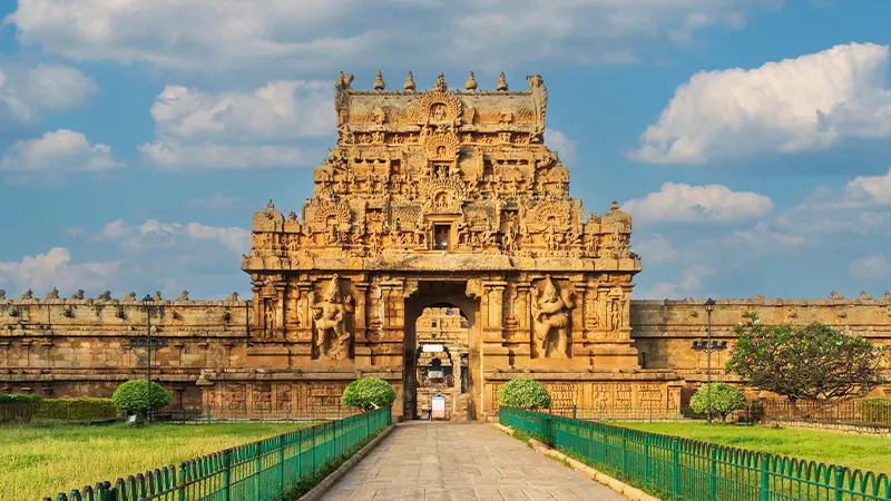 Grand Chola-era stone gateway with intricate carvings and temple architecture