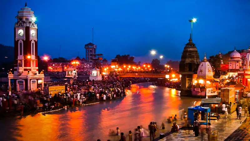 Devotees gathered along a riverside promenade during evening prayers