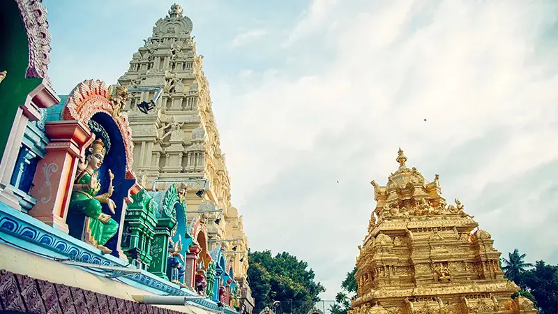 Golden vimana and colorful temple towers within a revered spiritual campus