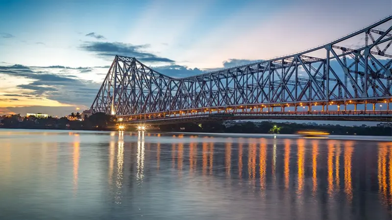 Howrah Bridge illuminated at sunset over the Hooghly River