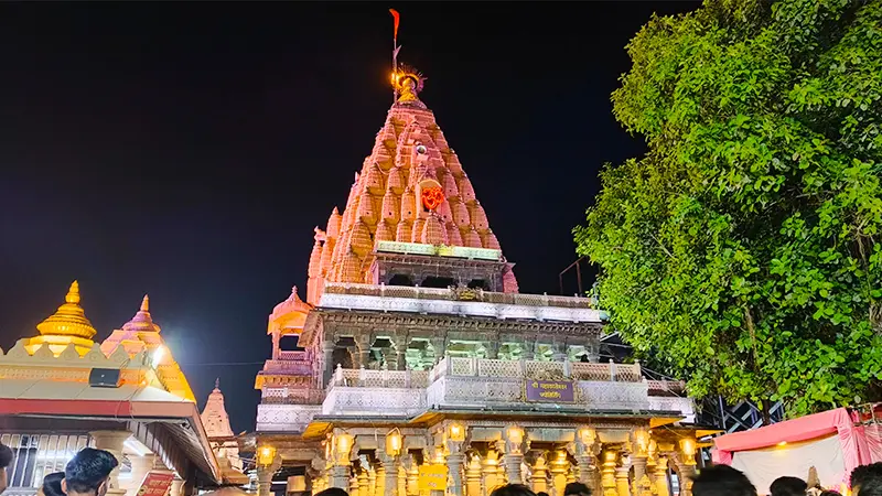 Temple spire glowing with lights during a vibrant evening celebration