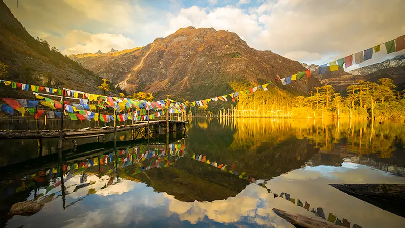 Khecheopalri Lake with colorful prayer flags in West Sikkim
