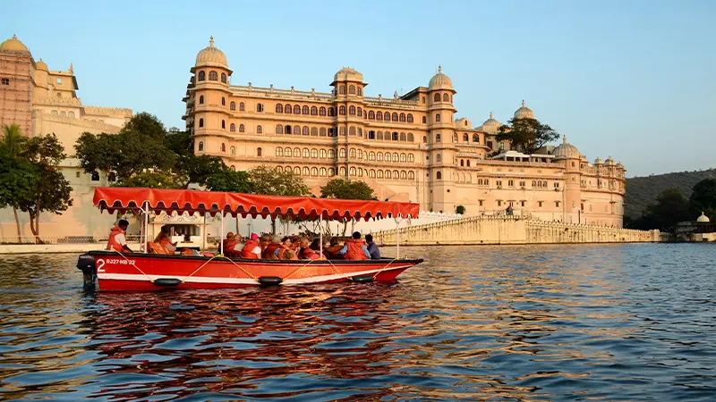 Tourist boat ride on Lake Pichola with Udaipur City Palace in the background
