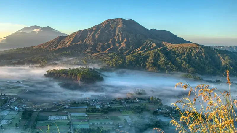 Sunrise view of Mount Batur and mist-covered valley in Bali