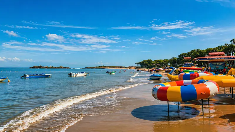 Water sports and boats along the sandy shore of Nagoa Beach