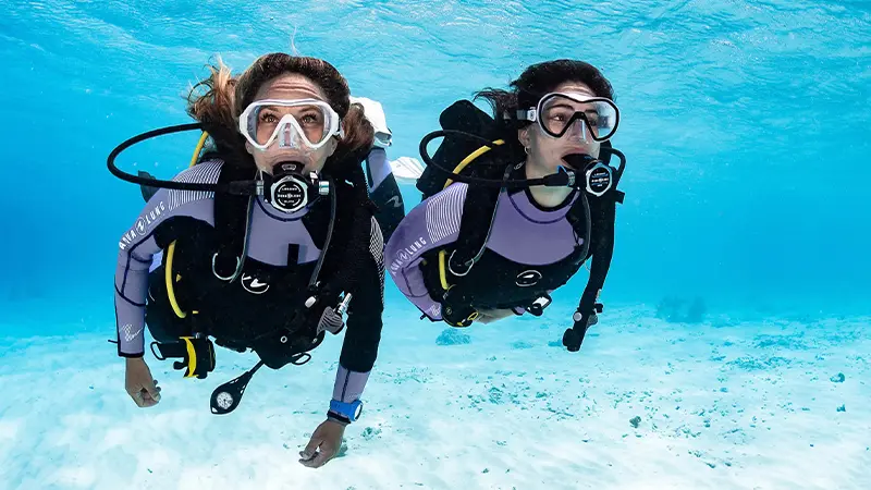 Scuba divers exploring clear blue waters in Andaman
