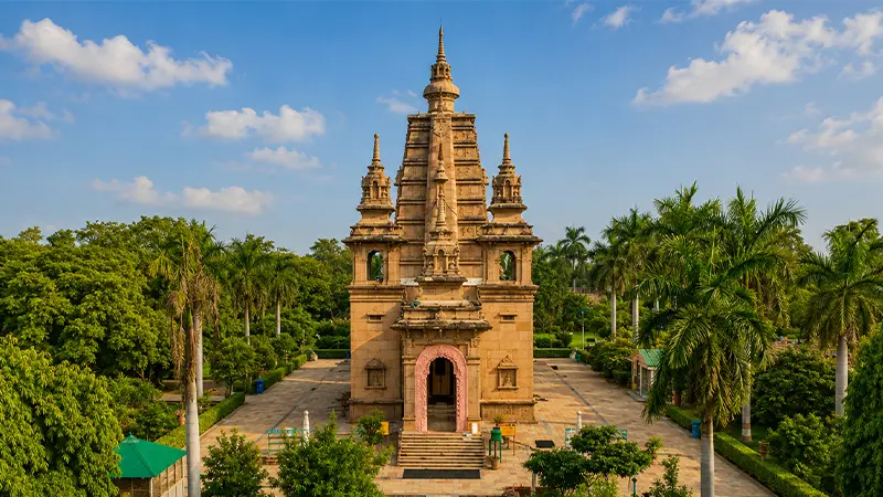 Historic monument surrounded by palm-lined gardens and landscaped pathways