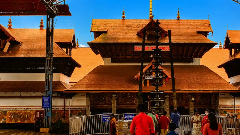 Pilgrims walking through the entrance pathway of a revered temple complex