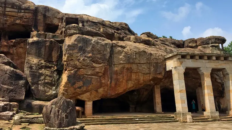 Ancient rock-cut monastic complex carved into natural sandstone cliffs
