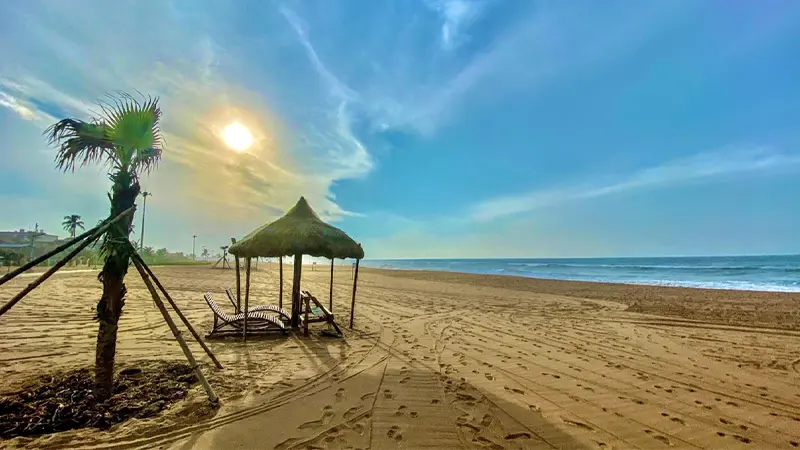 Golden sunrise illuminating a peaceful seaside recreation area with sandy shores
