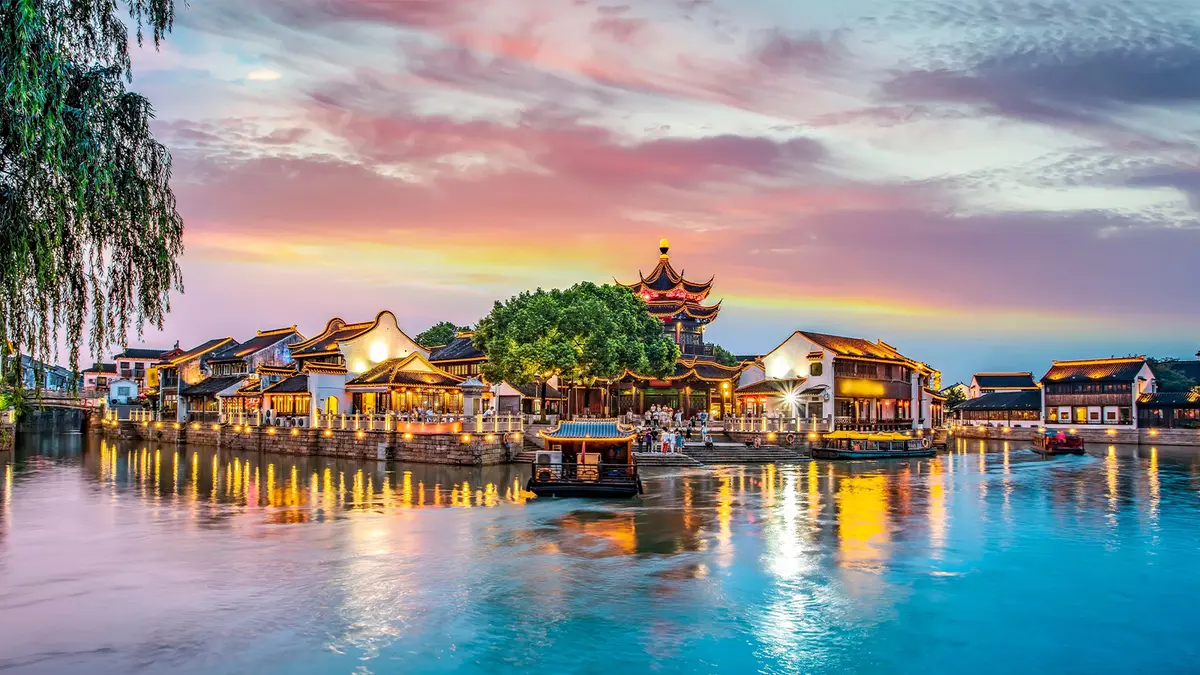 Historic riverside water town illuminated at sunset in Thailand