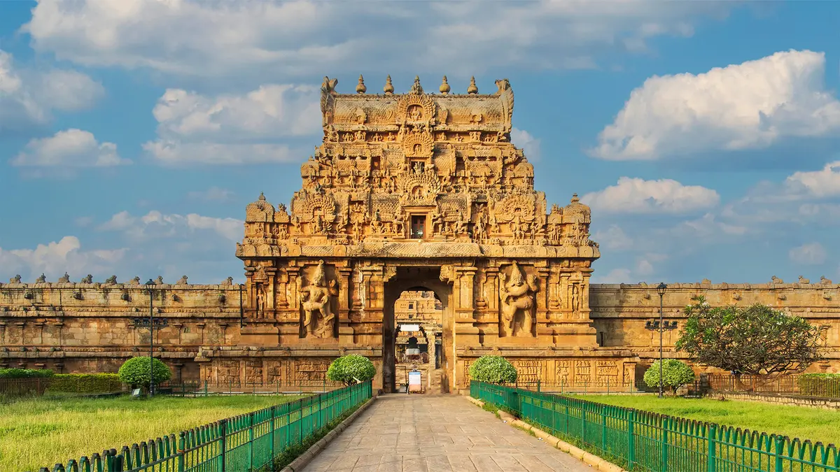 Grand Chola-era stone gateway with intricate carvings and temple architecture