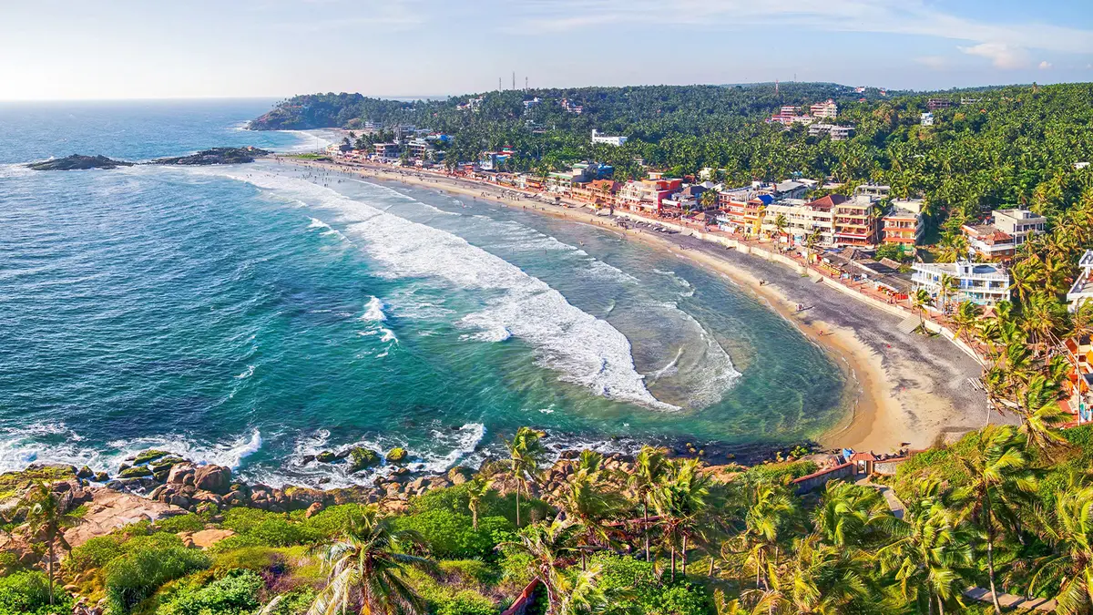 Scenic crescent-shaped coastline lined with palm trees and seaside settlements
