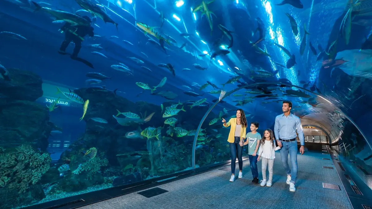 Family exploring the underwater tunnel at Dubai Aquarium and Underwater Zoo