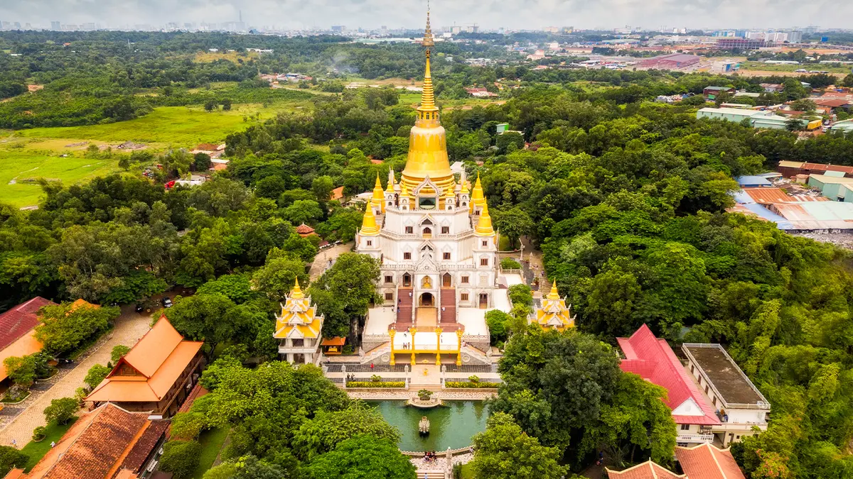 Aerial view of a golden Buddhist pagoda surrounded by lush greenery