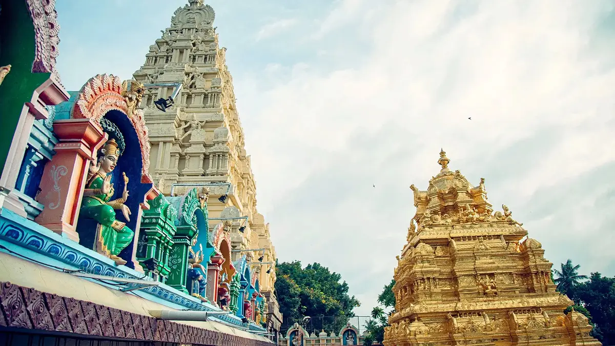 Golden vimana and colorful temple towers within a revered spiritual campus
