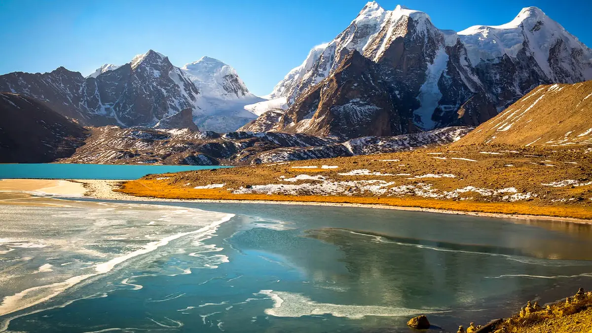 Gurudongmar Lake surrounded by snow-covered Himalayan peaks in North Sikkim