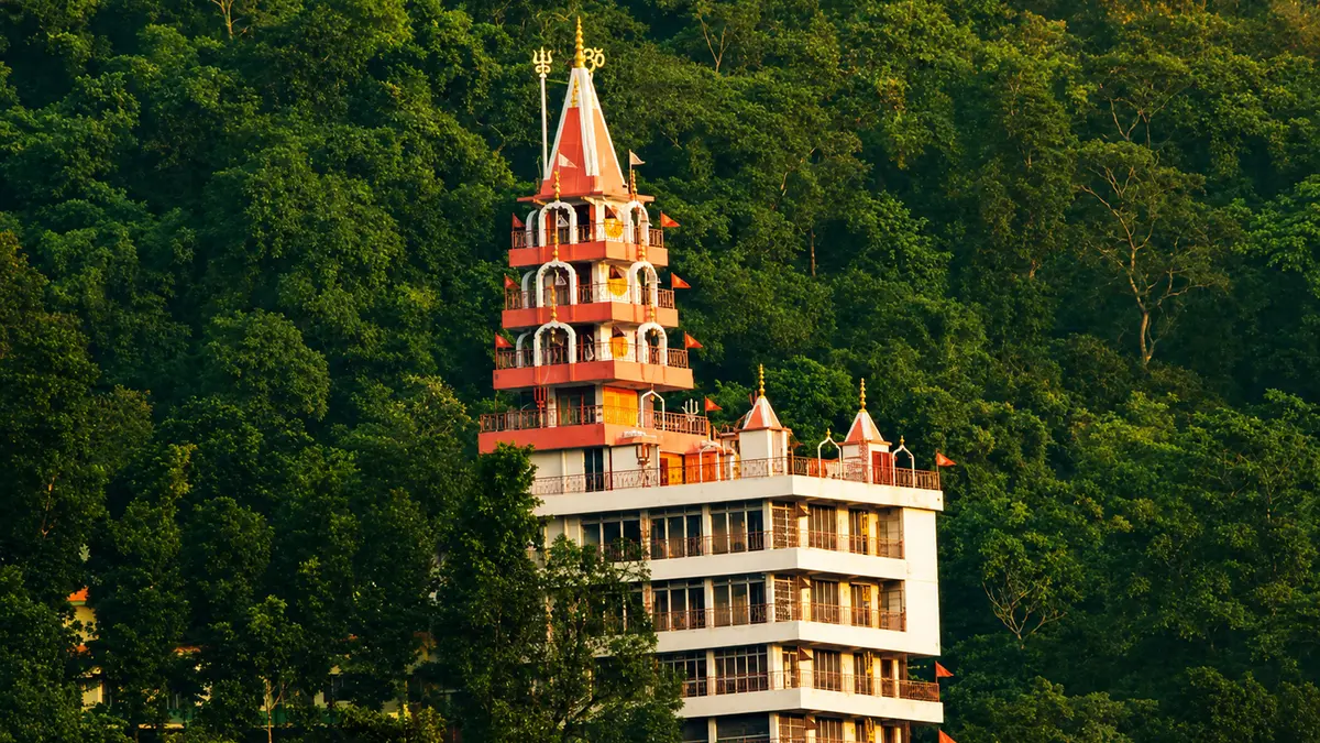 Multi-storey spiritual retreat tower surrounded by lush Himalayan forests