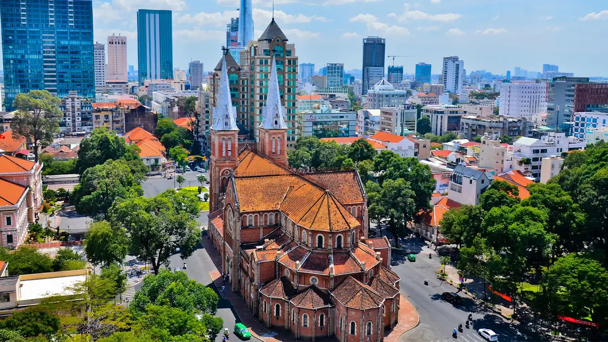 Historic cathedral rising above a modern city skyline in Vietnam
