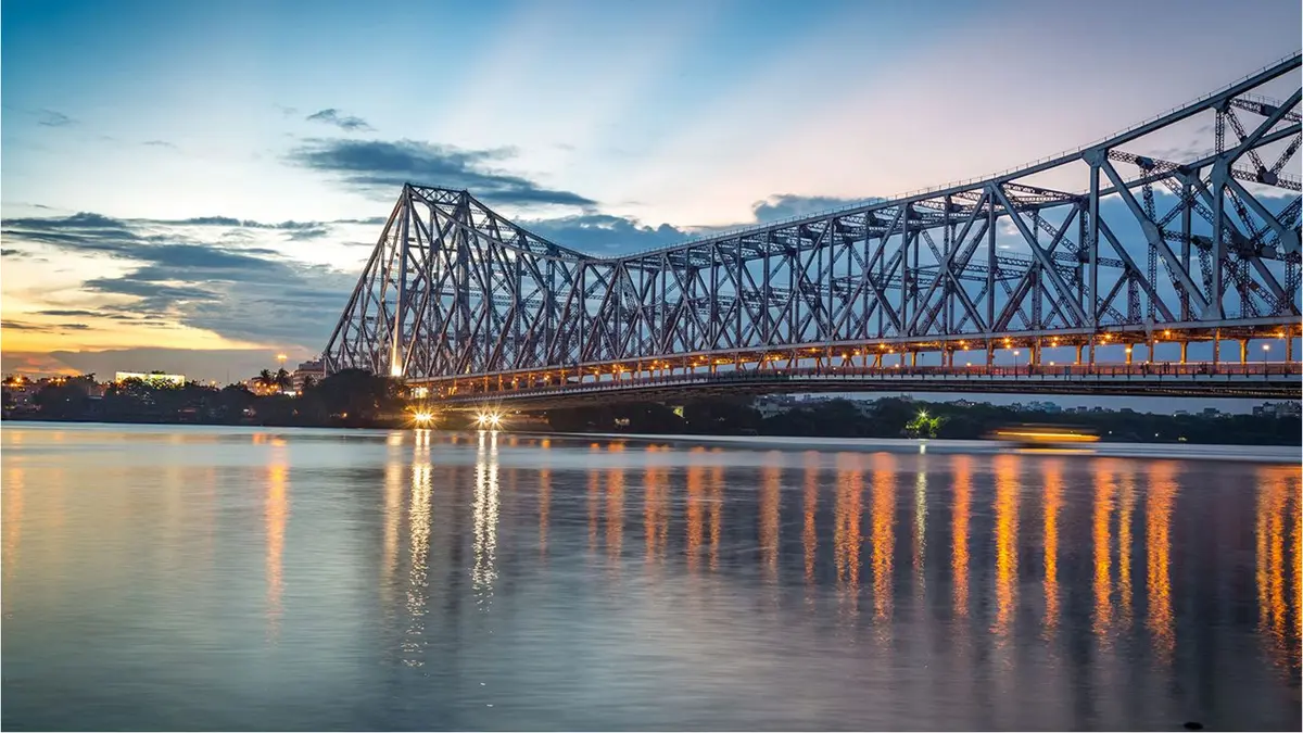Howrah Bridge illuminated at sunset over the Hooghly River