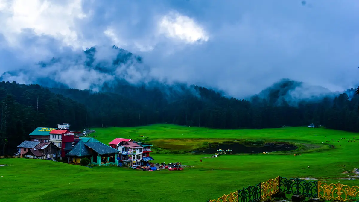 Lush green Khajjiar meadow surrounded by pine forests during the monsoon season