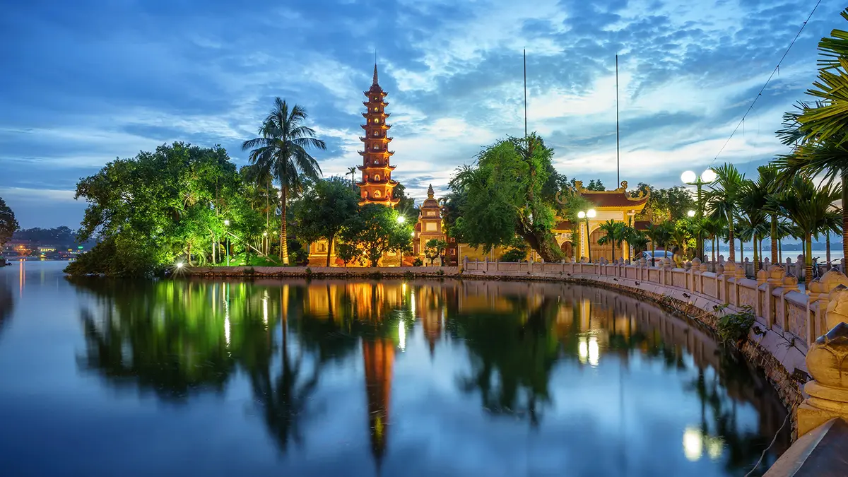 Ancient pagoda reflected in a calm lakeside setting after sunset