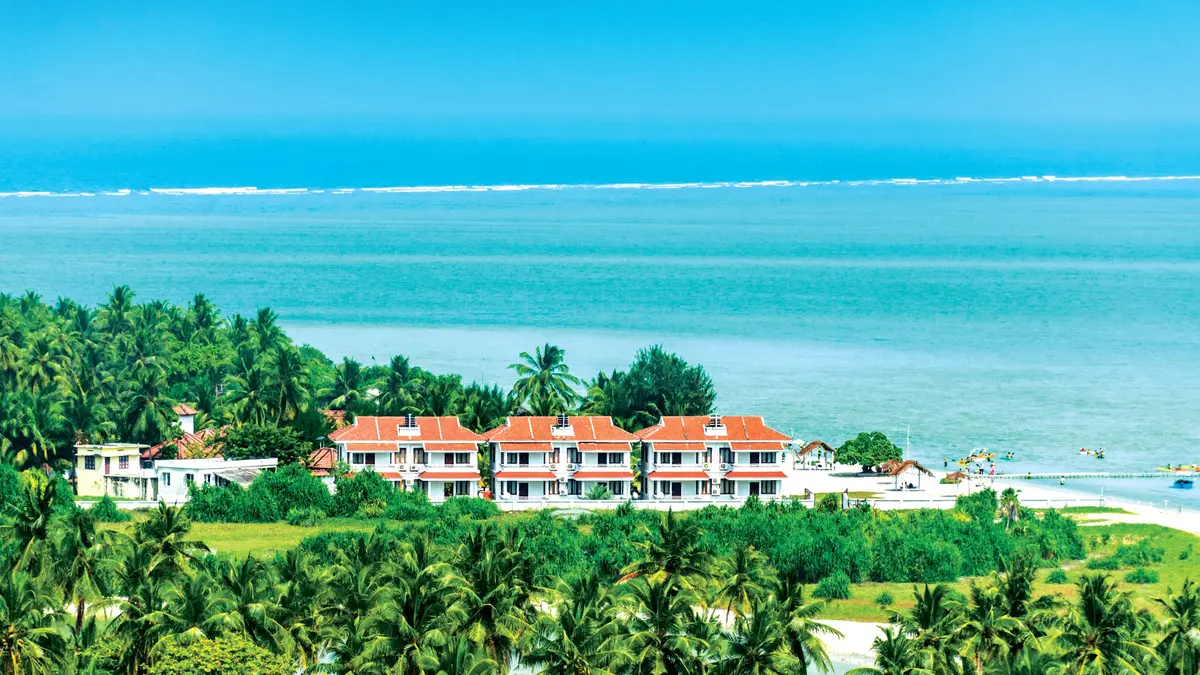 Beachfront resort surrounded by coconut palms on a Lakshadweep island