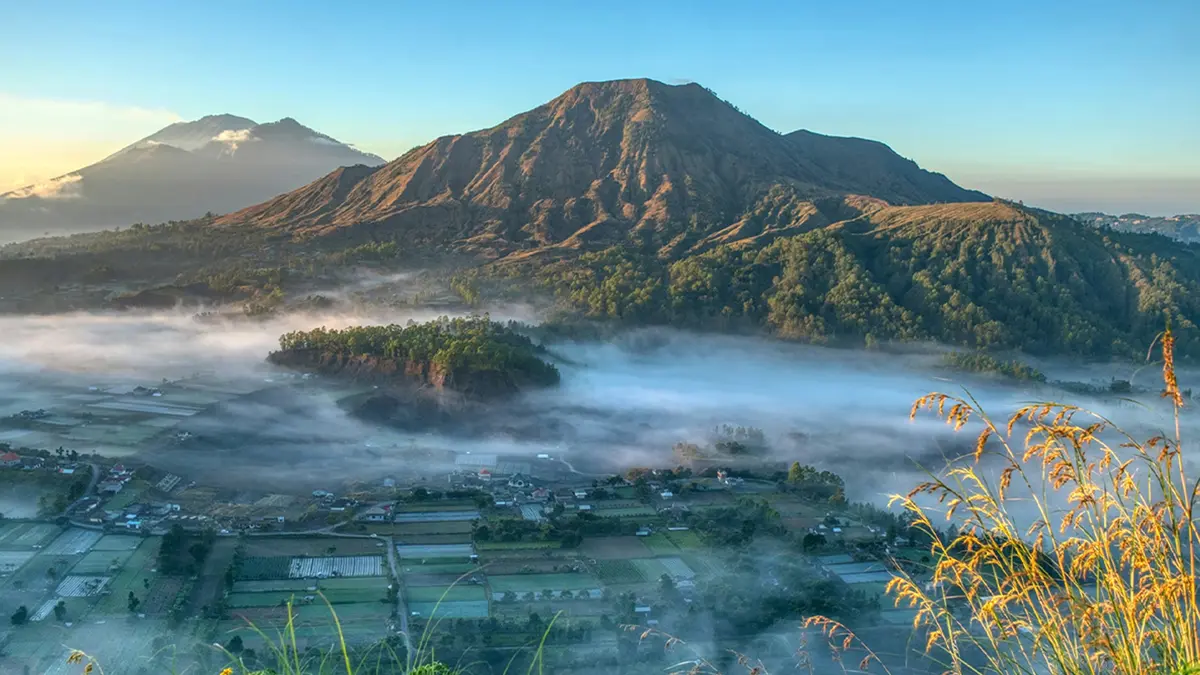 Sunrise view of Mount Batur and mist-covered valley in Bali