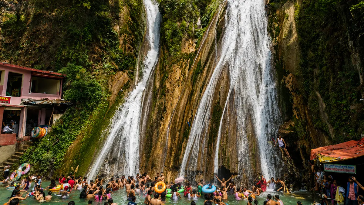 Visitors enjoying a natural waterfall and mountain stream pool