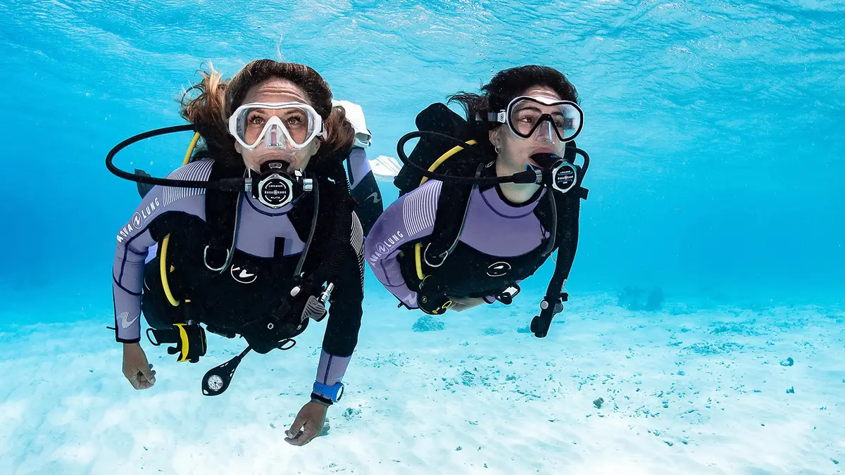 Scuba divers exploring clear blue waters in Andaman