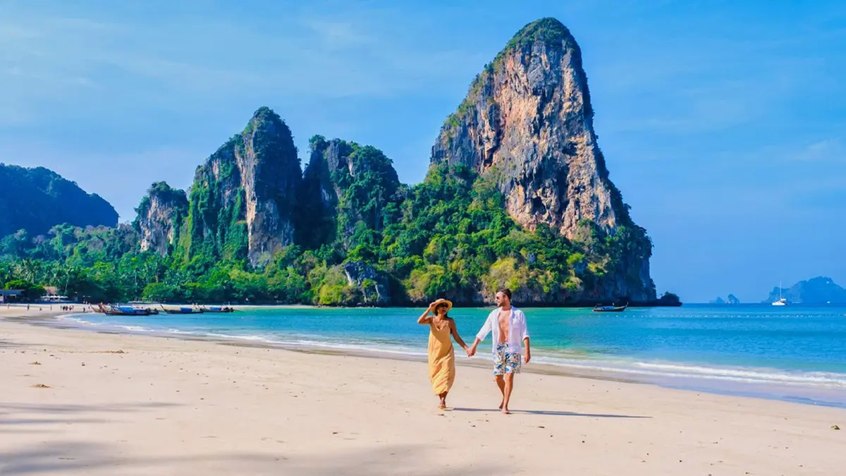 Couple walking along Railay Beach in Krabi