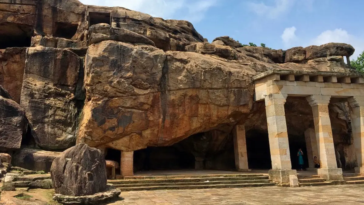 Ancient rock-cut monastic complex carved into natural sandstone cliffs