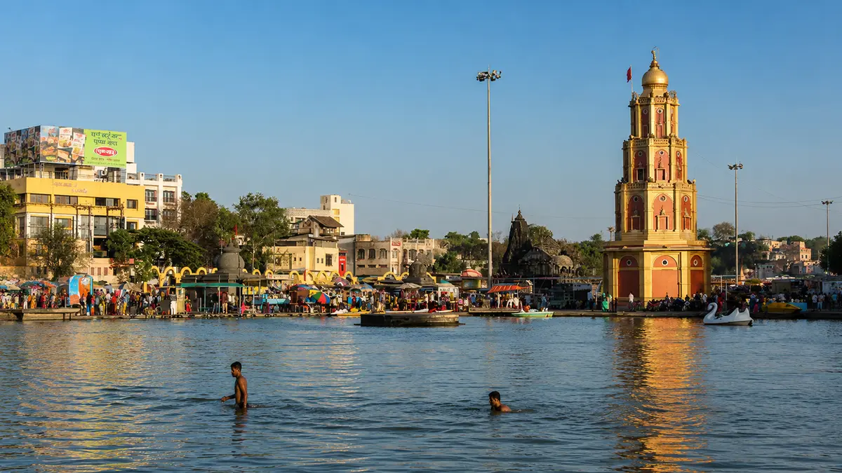 Historic clock pavilion overlooking a sacred reservoir visited by pilgrims and travelers