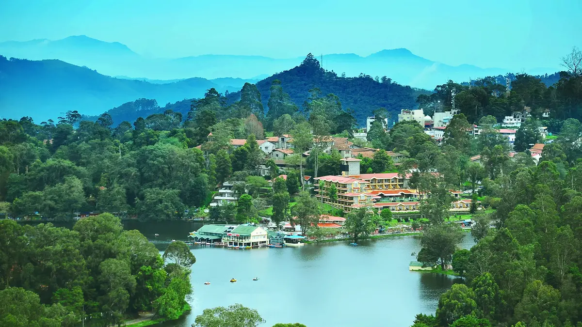 Scenic hill lake townscape surrounded by forests and misty mountains