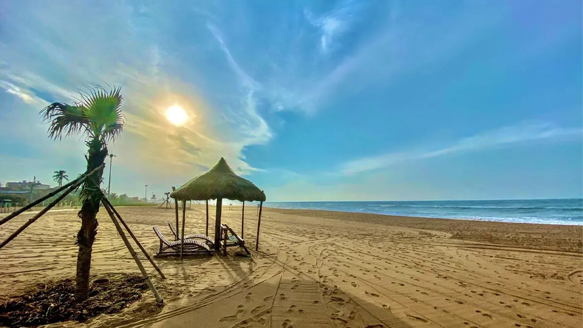 Golden sunrise illuminating a peaceful seaside recreation area with sandy shores