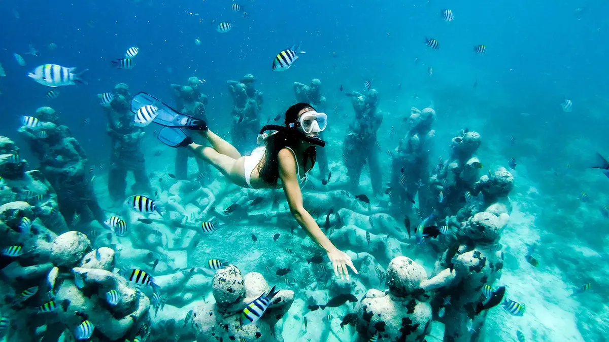 Woman snorkeling with tropical fish in Andaman Sea