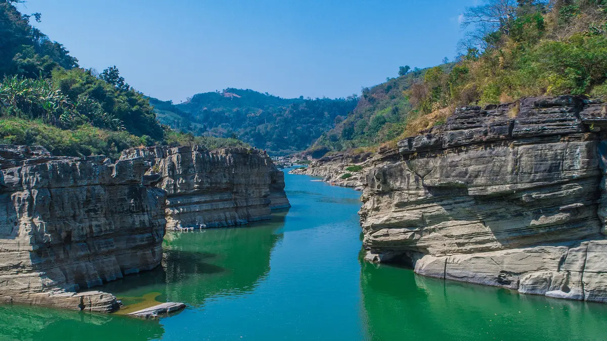 Rocky river gorge surrounded by lush forests in Mizoram