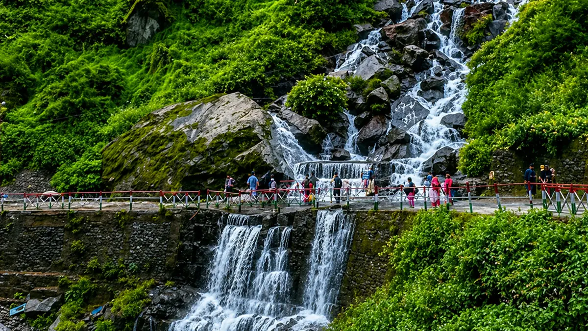 Pilgrims walking near Vasudhara Falls on the Badrinath route