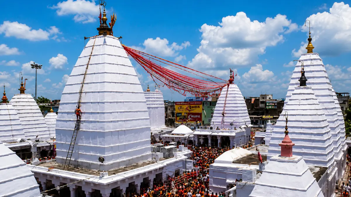 Historic white temple complex adorned with ceremonial decorations and pilgrims