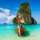 Thailand longtail boat with turquoise sea and limestone cliffs